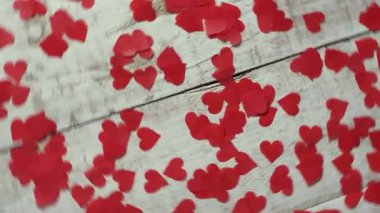 Beyaz ahşap yüzeyde dönen romantik kırmızı kalpler. Sevgililer Günü, aşk, ilişkiler ve düğün temalı projeler için mükemmel.. 