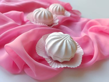 Gri ve pembe kumaş arka planda beyaz ve pembe lokum.