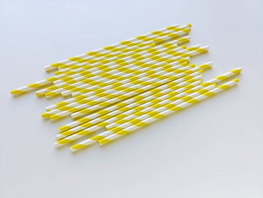 Beyaz arka planda sarı ve beyaz çizgili kağıt kokteyl pipetleri