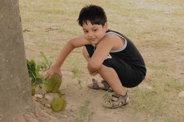 Ragazzo Seduto Alla Base Albero Jackfruit Giocare Con Jackfruits Ambiente — Foto Stock