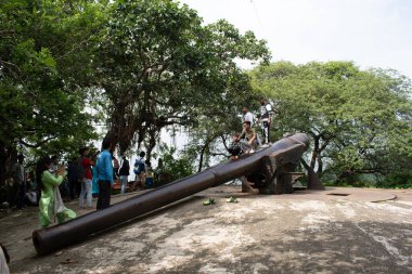 Fil Adası, navi mumbai, Hindistan - 12 Ağustos 2023: ziyaretçiler tepenin üstünde muhafaza edilmiş antika toplarla poz veriyorlar