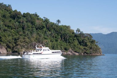 Guaiba adası, Rio de Jeneiro, Brezilya - 12 Mayıs 2024: Dağ arka planında suda yüzen bir yat