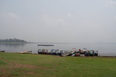 Patratu Gölü, Ranchi, Jharkhand, Hindistan - 14 Temmuz 2024: kayıkçı ve dekore edilmiş eğlence tekneleri turistler için geçici iskeleyle gölün kıyısında