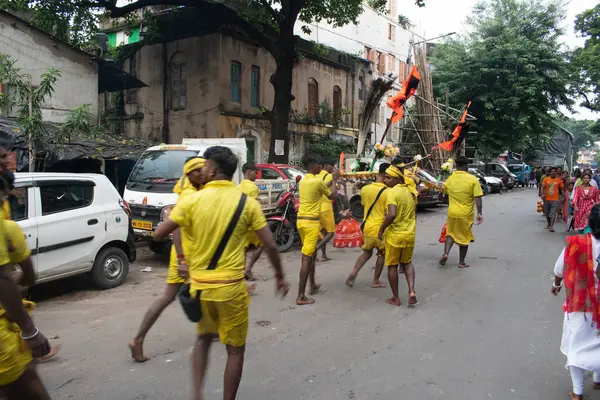 stock image kumartuli, Kolkata, west bengal, india - august, 25, 2024 : hindu pilgrims march on the road with traditional holy equipments and ethnic dress on the eve of auspicious 