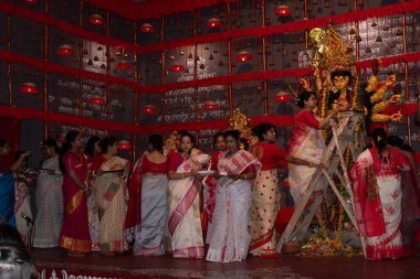 khanpur, kolkata, west bengal, india-october 12, 2024:bengali women performing 'vermilion ceremony' on 'dussera' with goddess 'durga' idol, an hindu ethnic culture of woman with living husband clipart