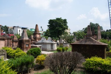 chinsurah (chuchura), West Bengal, Hindistan 23 Temmuz 2025: tarihi Hollanda mezarlığı, iyi bakımlı, çalılar, sivri uçlu manikürlü bahçe yatakları ve piramit çatısı ile taçlandırılmış mozoleler