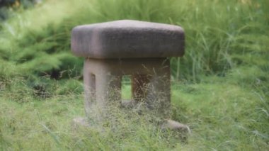 Japon bahçesindeki taştan bir feneri kapat. Yavaş çekim. 