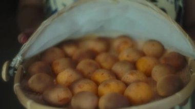 Geleneksel Brezilya peynirli ekmek ve tatlı patates sepeti. Yavaş çekim, yüzeysel alan derinliği.
