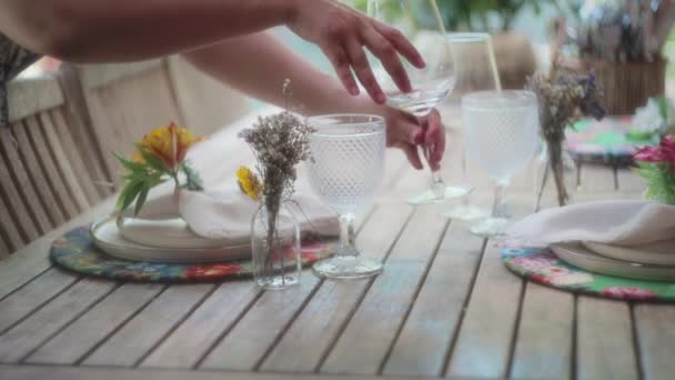 美しい装飾の隣の木製のテーブルの上にワイングラスを置く女性 スローモーション フィールドの浅い深さ — ストック動画