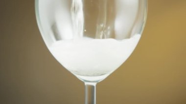 White sparkling wine being poured into a wineglass. Slow motion. 