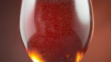 Small air bubbles floating in the rose wine in a wineglass. Slow motion. 