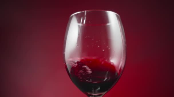 Kırmızı Arka Planda Şarap Kadehinin Içinde Kırmızı Şarap Sallanıyor Yavaş — Stok video