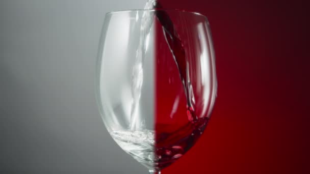 Kırmızı Gri Arka Planda Bir Bardağa Dökülen Beyaz Kırmızı Şarabın — Stok video