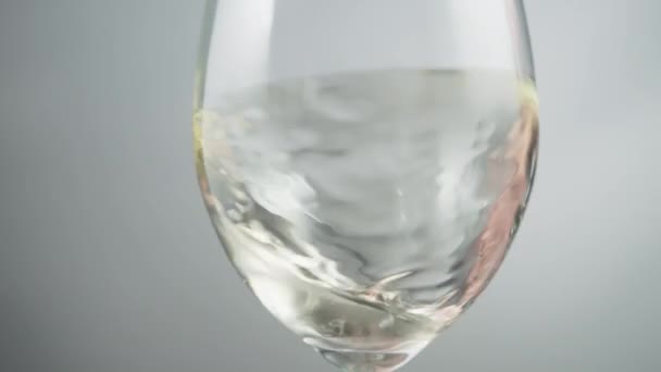 Close White Wine Waving Wineglass Grey Background Slow Motion — Stock video