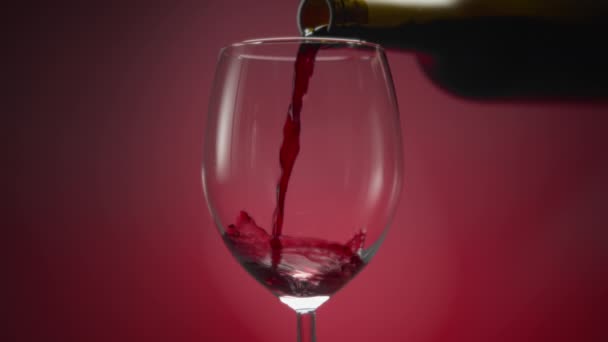 Червоне Вино Виливають Пляшки Склянку Червоному Тлі Повільний Рух — стокове відео