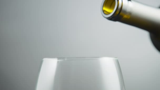 ボトルからグレーの背景のガラスに白ワインを注ぐ スローモーション — ストック動画