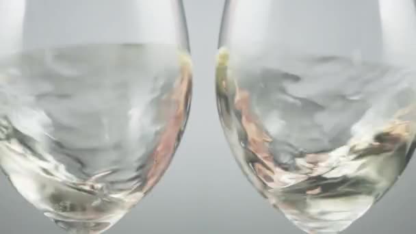Two Wine Glasses Shaking Swirling White Wine Grey Background Slow — Stock video