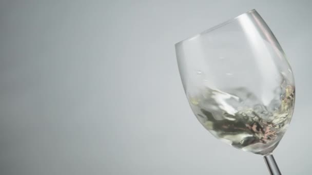 Close White Wine Swirling Wineglass Grey Background Slow Motion — Stock video