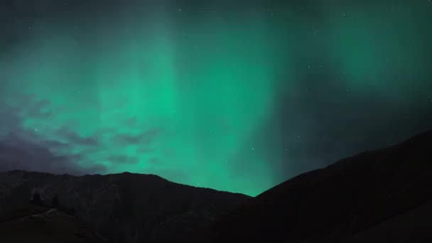 Aurora Borealis Northern Lights Brilha Acima Algumas Montanhas Enquanto Nuvens — Vídeo de Stock