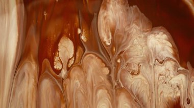 Kahverengi sıvı renkler yavaşça yüzeyde akıyor. Soyut makro arkaplan. 