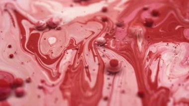 Soyut bir arkaplanda kırmızı ve pembe sıvı renkler akıyor. 