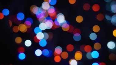 Siyah bir arkaplanda çeşitli renklerde soyut bokeh ışıkları. 