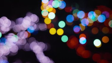 Siyah bir arkaplanda çeşitli renklerdeki bulanık bokeh ışıkları. 