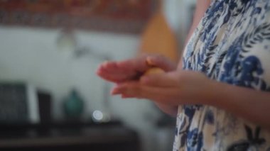 Kadın aşçı, geleneksel Brezilya peynirli çöreğini eline alıyor. Yavaş çekim, yüzeysel alan derinliği. 