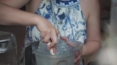 Kadın şef karıştırılmış macunu bir spatulayla karıştırıyor. Yavaş çekim, yüzeysel alan derinliği. 