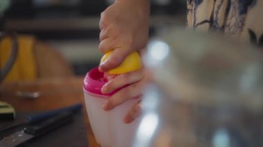 Limondan limon suyu sıkan bir kadın şef. Yavaş çekim, yüzeysel alan derinliği. 