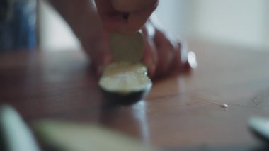 Şef bir kaşıkla kabağın içini temizliyor. Yavaş çekim, yüzeysel alan derinliği. 