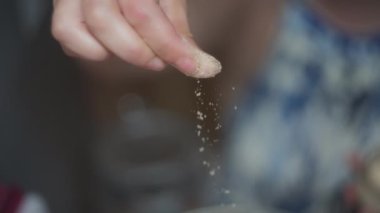 Şefin parmakları karıştırıcıya baharat serpiyor. Yavaş çekim, yüzeysel alan derinliği. 