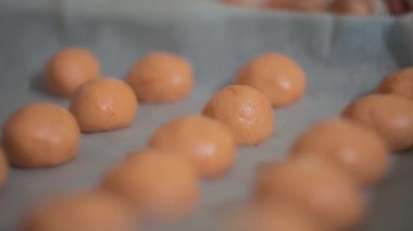 Parşömen kağıdıyla kaplanmış geleneksel Brezilya peynirli çörekler. Yavaş çekim, yüzeysel alan derinliği. 