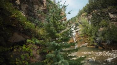 Kanada Waterton Ulusal Parkı 'ndaki kayaların arasındaki Cameron Şelalesi manzarası. Yavaş çekim. 