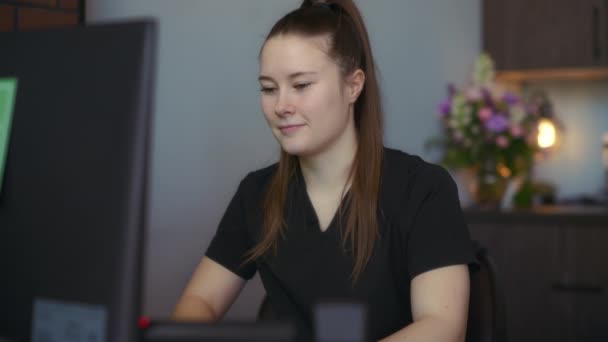 診療所受付のパソコンの机に座っている受付看護師 スローモーション — ストック動画