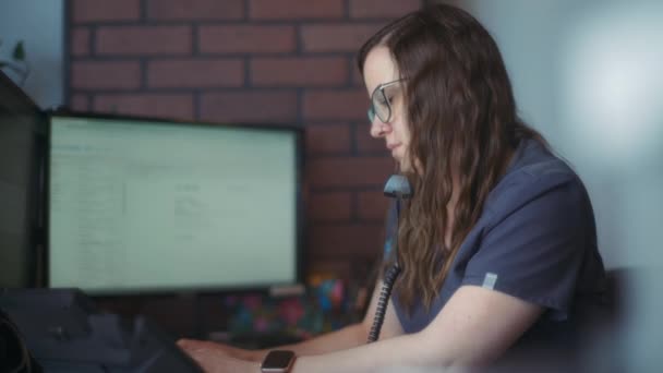 顧客と話している間にコンピュータに入力している獣医の受付係 スローモーション — ストック動画