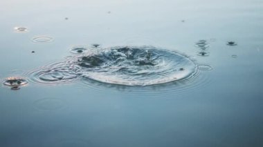 Taşın suya düşmesi yüzeyde dalgalanmalar yaratır. Yavaş çekim. 
