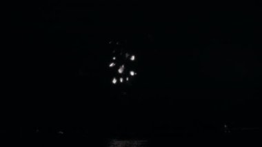 Havai fişekler göl suyunun üstündeki gece gökyüzünü aydınlatıyor.. 