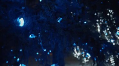 Geceleri bir Noel ağacında asılı duran mavi çelenk. Yavaş çekim. 