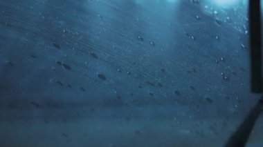 Şiddetli bir yağış sırasında araba silecekleri yavaş yavaş ön cama çarpıyor. Ağır çekim, yakın çekim..