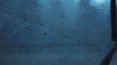 Şiddetli bir yağış sırasında araba silecekleri yavaş yavaş ön cama çarpıyor. Ağır çekim, yakın çekim.. 