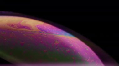 Sabun köpüğü yüzeyinde çeşitli renklerde sıvılar hareket ediyor. Soyut makro arkaplan. 