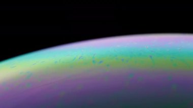 Bir sabun köpüğünün yüzeyinde hareket eden renkler. Makro olarak soyut arkaplan.