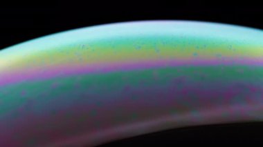 Kabarcık sıvı yüzeyinin canlı renkleri soyut şablonda akıyor. 