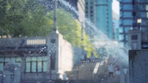 水噴水が街の背景に飛びついています スローモーション — ストック動画