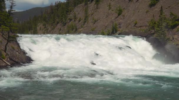 カナダのバンフ国立公園の岩の間をカスケードするボウフォールズ スローモーション — ストック動画