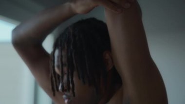 Evinde esneme hareketleri yapan bir adamı yakından çek. Sağlıklı yaşam tarzı ve spor. Yavaş çekim. 