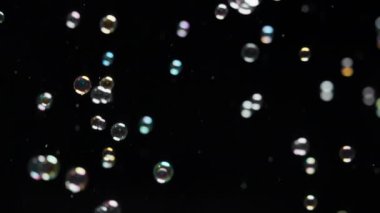 Siyah arka planda uçuşan sabun köpükleri. Üst üste, arka plan. Yavaş çekim. 