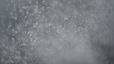 Gümüş gri parıltılı konfeti ağır çekimde patladı. 