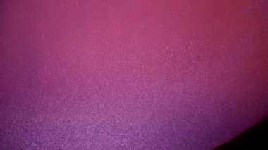 Soyut ağır çekimde yüzen mor simli parçacıklar. 